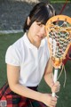 A young woman holding a lacrosse stick on a field.