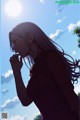 A woman with long hair standing in front of a blue sky.