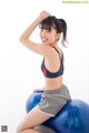 A woman sitting on top of an exercise ball.